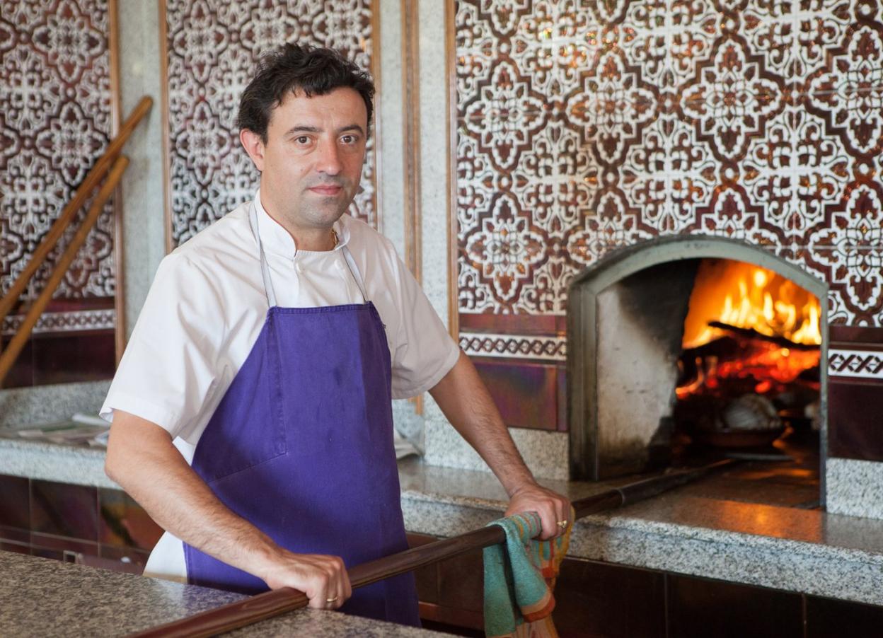 Roberto Cristóbal prepara el horno de leña, símbolo del asador.