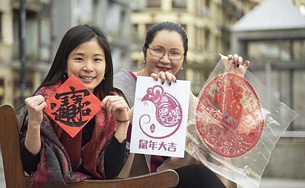 Szu Hua y Adela Lu posan con varias felicitaciones de este Año Nuevo chino, como el símbolo de la rata de oro