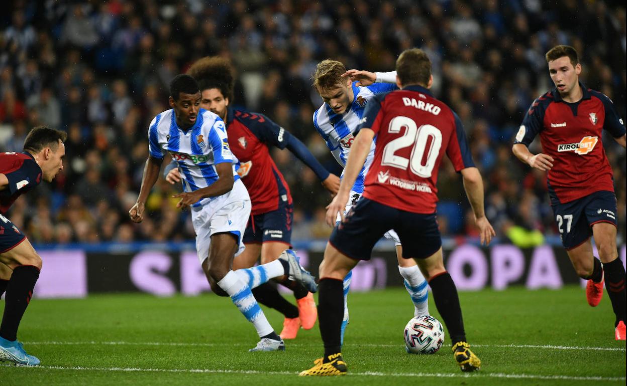 Odegaard conduce un balón entre varios jugadores rojillos. 