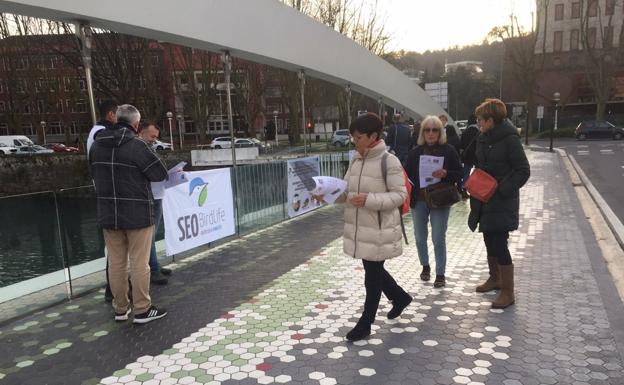 Miembros del grupo local de Seo Birdlife Donostia reparten información sobre el cristal y las aves en el puente Lehendakari Agirre.