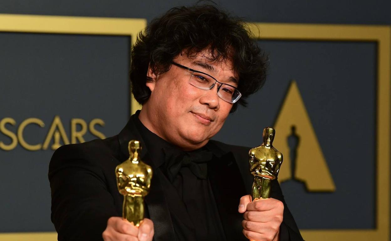 Bong Joon-ho sostiene dos de los cuatro Oscar que ha obtenido 'Parásitos'.