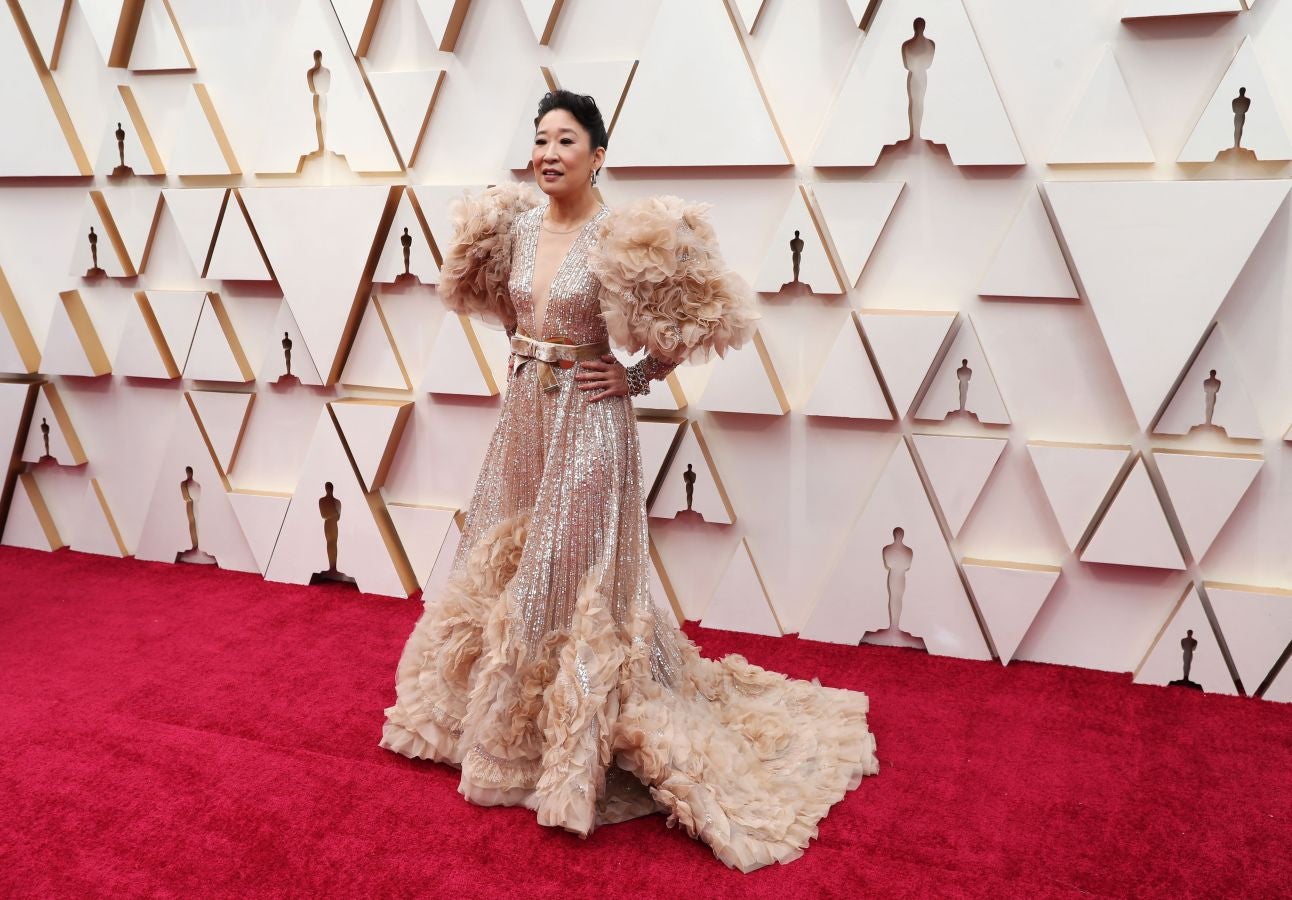 Sandra Oh ha sido una de las actrices más ostentosas de la noche, gracias a una creación de Alta Costura del libanés, Elie Saab. La pieza, perteneciente a la colección primavera-verano 2020, está compuesta por paillettes, un gran lazo de terciopelo marcando cintura, volantes y un pronunciado escote. La actriz ha optado por complementar el vestido con unas sutiles joyas, el pelo recogido y un maquillaje en tonos tierra 