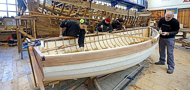Alumnos y profesores de la escuela de carpintería de Albaola dan los últimos retoques al casco del segundo 'water wag' que se hace en la factoría.