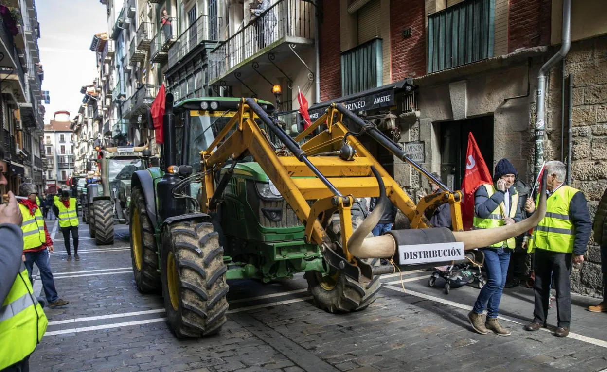 Seis tractores 'tuneados' de toro avanzan por la calle Estafeta de Pamplona en la simulación del encierro de San Fermín.