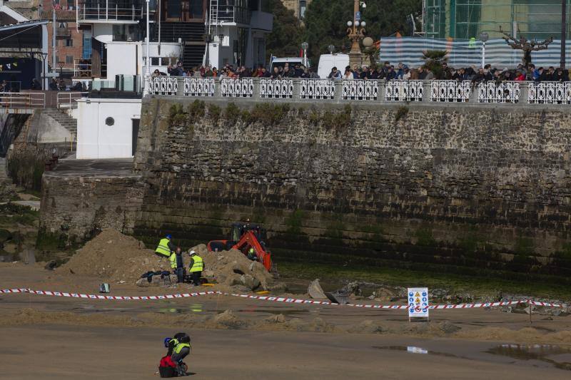 La playa de La Concha se ha convertido en la bajamar de este lunes por la mañana en un inesperado yacimiento arqueológico. La presencia de una pequeña excavadora retirando piedras y escombros junto al muro de costa a la altura del edificio consistorial ha suscitado una gran expectación entre los numerosos viandantes y turistas que han provechado el buen tiempo para dar un paseo. La máquina profundizaba en la arena en busca de los restos de un barco hundido del que hay constancia documental desde el siglo XVIII. 