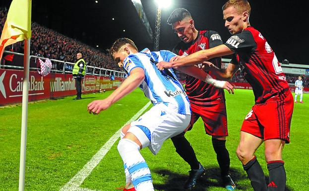 Adnan Januzaj protege un balón en el córner ante el acoso de dos rivales del Mirandés. 