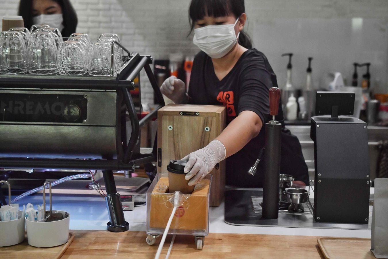 Una cafetería de Bangkok ha ideado este sistema rudimentario a la par de original para que los clientes puedan pagar sus cafés respetando las distancias de seguridad.