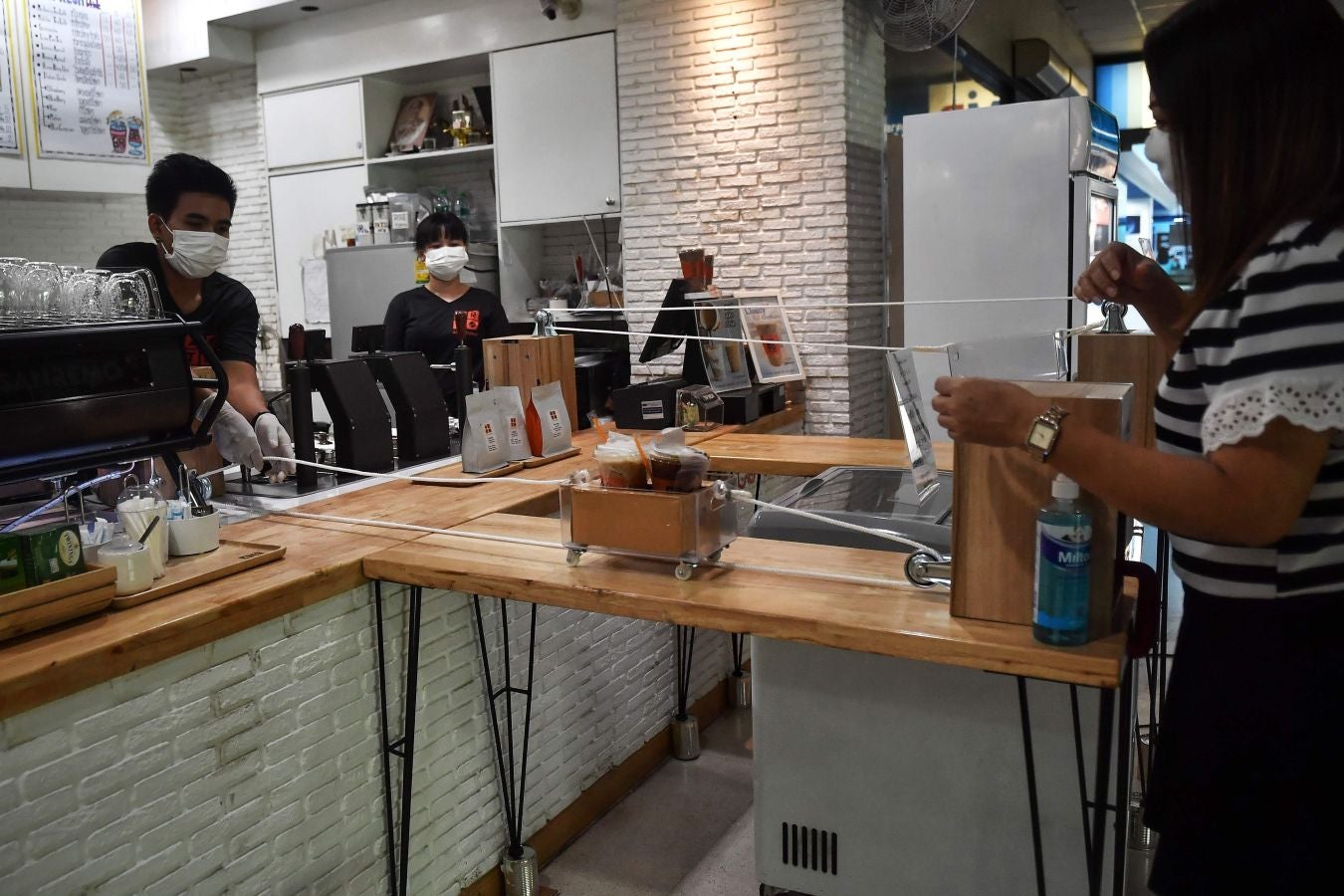 Una cafetería de Bangkok ha ideado este sistema rudimentario a la par de original para que los clientes puedan pagar sus cafés respetando las distancias de seguridad.