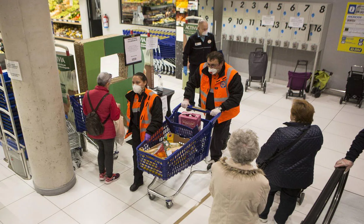 Dos voluntarios de Protección Civil de Irun compran alimentos en un establecimiento de la ciudad. 