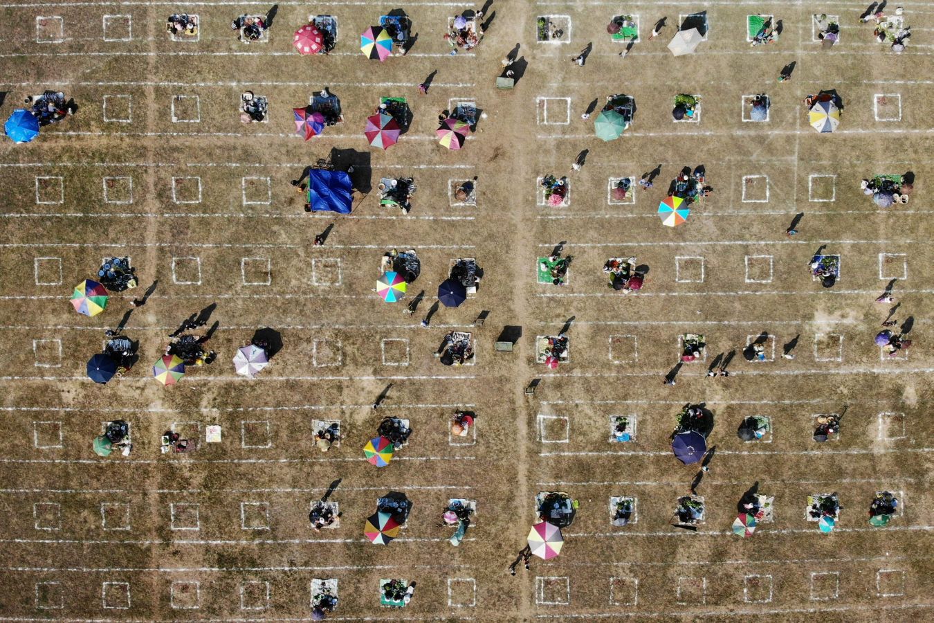 Una localidad de Myanmar ha decido utilizar un campo de fútbol para convertirlo en un gran mercado al aire libre. Sobre el maltrecho césped se han pintado nuevas líneas que ya no dibujan el centro del terreno de juego o las áreas, sino las distancias de seguridad para evitar la propagación del Covid-19.
