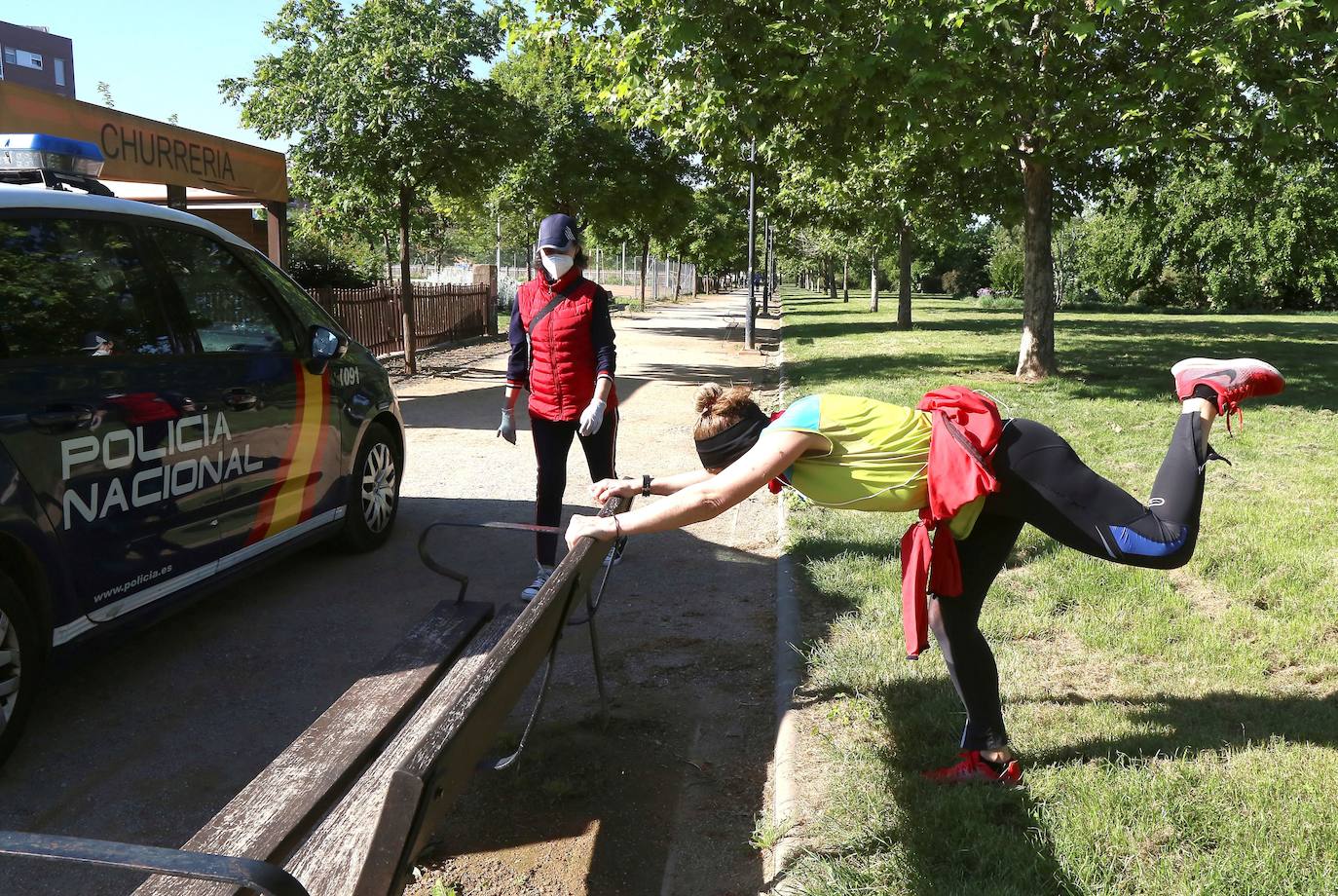 Una mujer estira después de correr por las calles de Granada.