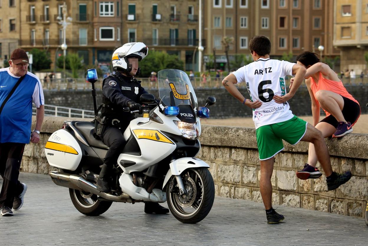 Un policía municipal llama la atención a dos jóvenes en la zona de Sagüés. 