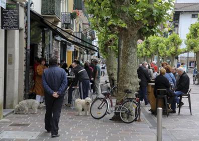 Imagen secundaria 1 - Arriba: El buen tiempo acompañó y las terrazas de La Marina estuvieron al completo casi todo el día. Izquierda: Desde que el lunes se permitió abrir los veladores, se han ido sumando establecimientos, que han empezado a retomarla actividad. Derecha: En Donostia se permite a algunos hosteleros ampliar el espacio para la terraza, como este, a ambos lados de la carretera.