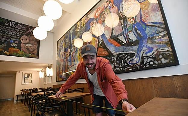 Metro en mano para la distancia entre mesas... Mikel López pone a punto su bar para reabrir mañana.