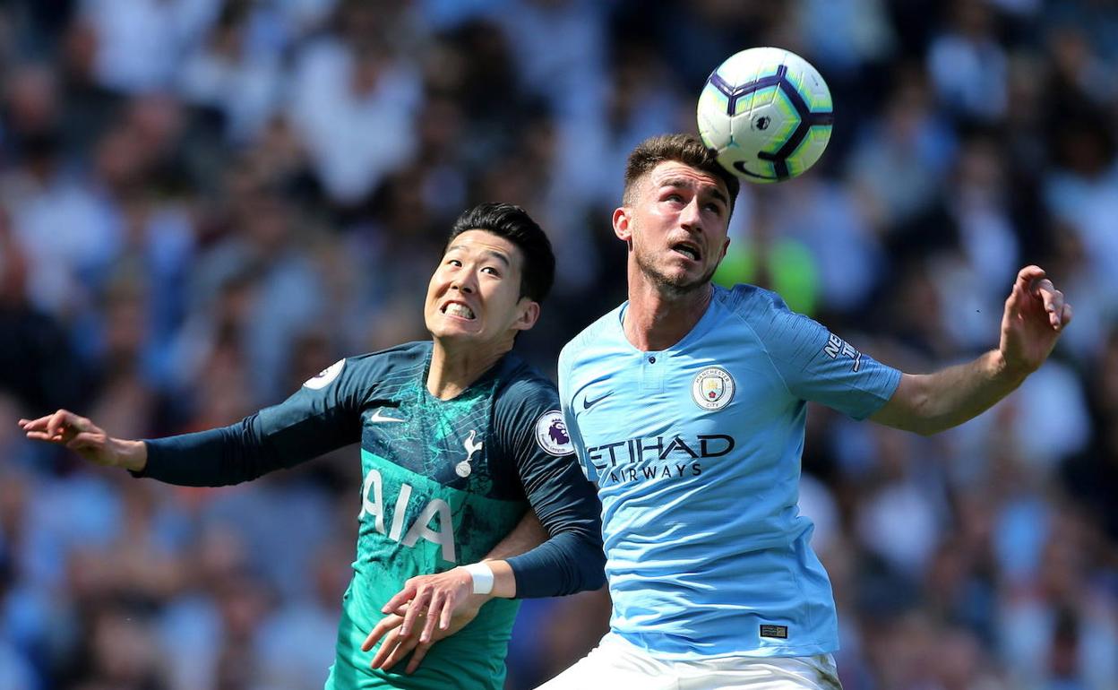 Heung-min Son y Aymeric Laporte disputan un balón. 