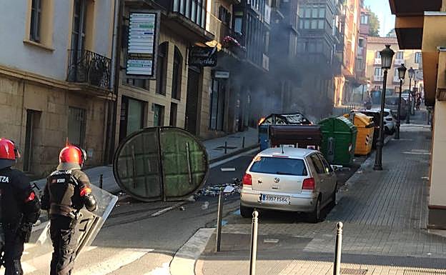 Imagen principal - Quema de contenedores en la calle Pikoketa y pitadas en la calle López de Becerra. 