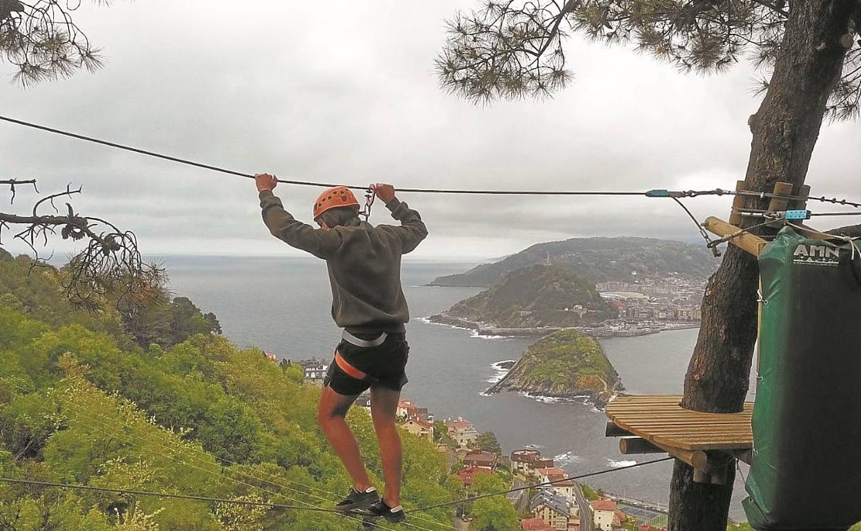 Un joven se enfrenta al paso de monos, uno de los retos del nuevo parque de tirolinas del monte Igeldo. 