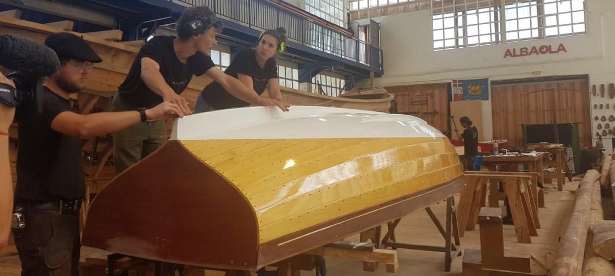Alumnos de la escuela de carpintería de Albaola dan los últimos retoques al casco del balandro.