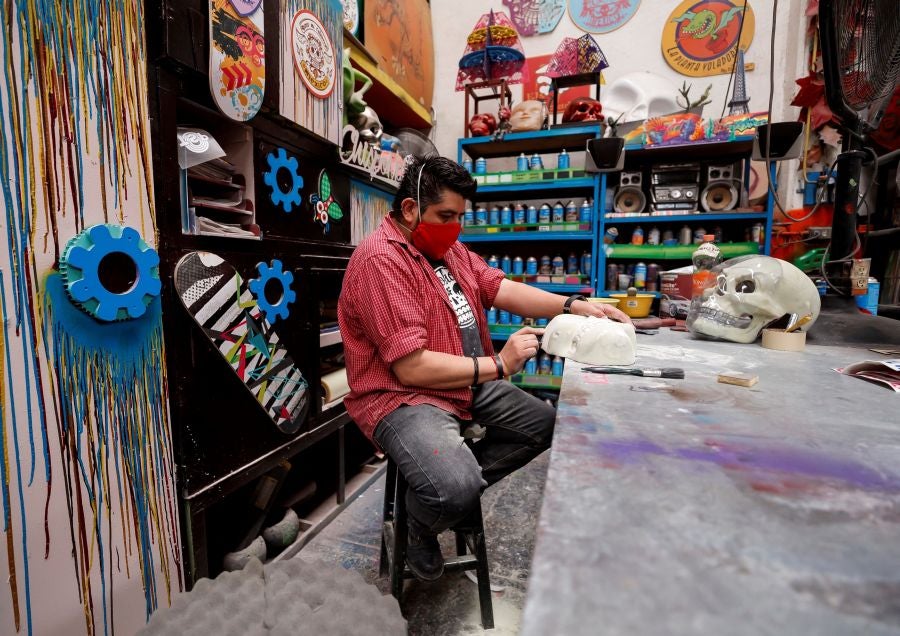 Vista de unos cubrebocas y caretas con diseños de calaveras creados en el taller El Volador en Ciudad de México. El taller mexicano de plástica El Volador que lleva más de 30 años haciendo máscaras, escenografías y ofrendas del Día de Muertos se ha reinventado con la fabricación de cubrebocas y máscaras inspirados en la cultura mexicana