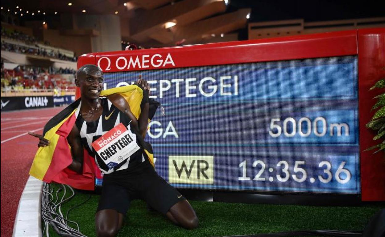 Joshua Cheptegei posa junto a la nueva plusmarca mundial de los 5.000 metros. 