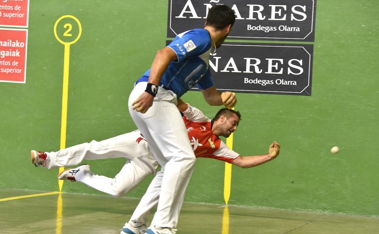 Oinatz Bengoetxea se lanza en plancha en el txoko ante la mirada de Joseba Ezkurdia, en el frontón Amazabal de Leitza. 