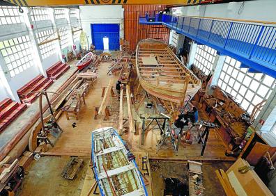 Imagen secundaria 1 - Arriba: el francés Rémi Fennebresque, trabajando en el taller de Albaola, donde tiene previsto permanecer como profesor. A la izquierda:el llamado 'antzoki' de la factoría es el lugar de trabajo y formación de los aprendices. A la derecha: en la botadura de un 'waterwag', uno de los dos veleros irlandeses que se han construido en Albaola.