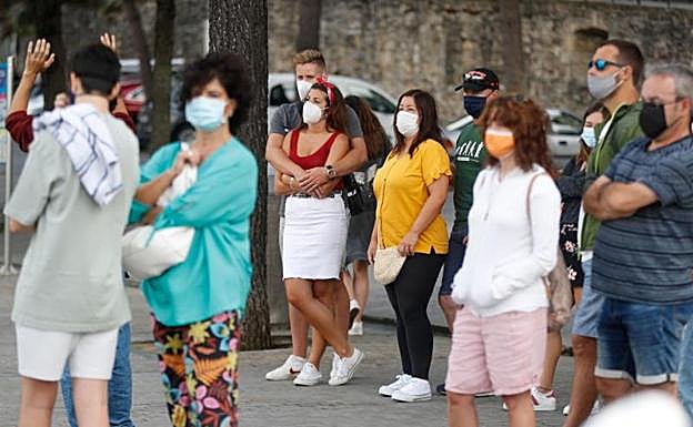Un grupo de visitantes atiende las explicaciones del guía en Donostia.