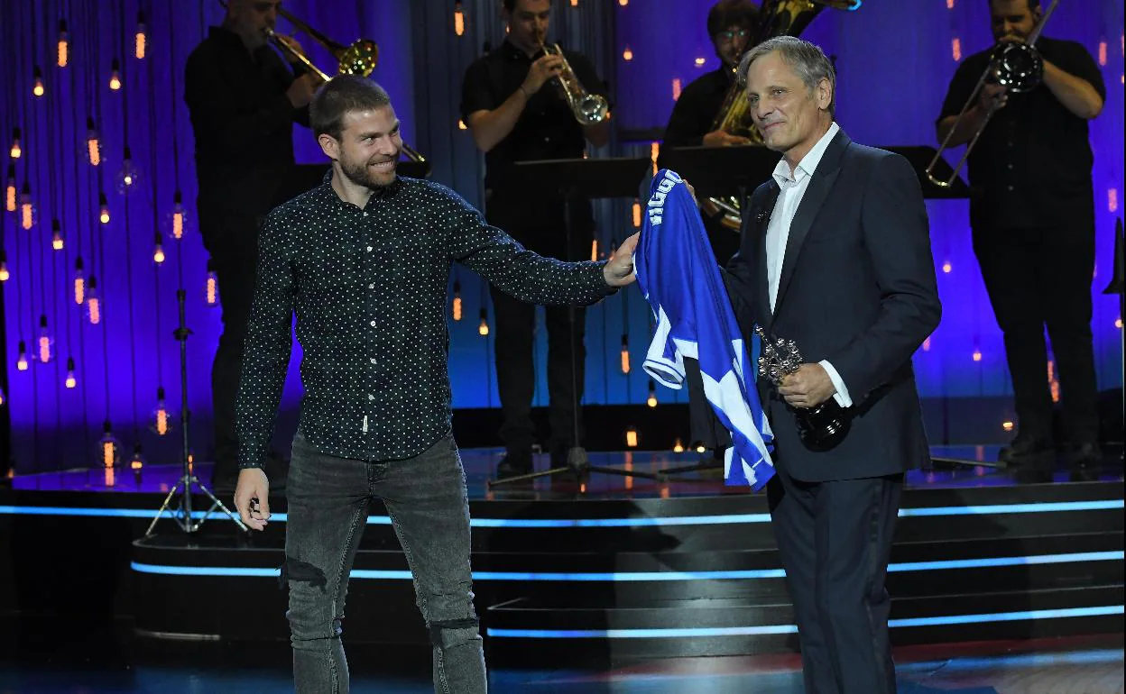 Viggo Mortensen recibe las camisetas de la Real y del San Lorenzo de manos de Asier Illarramendi. 