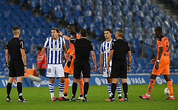 Oyarzabal y Guevara protestan al trío arbitral al final del partido por el gol anulado.