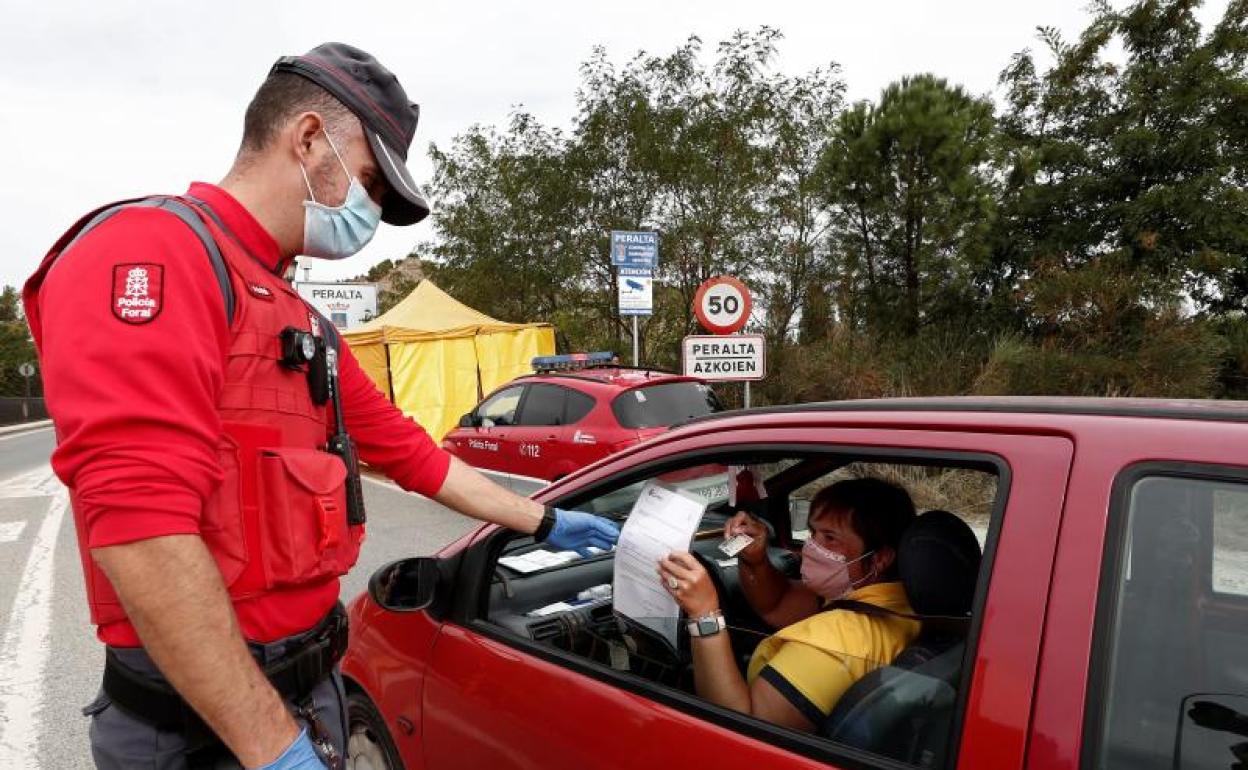 Un policía foral revisa la documentación de una conductora en un control en Navarra.