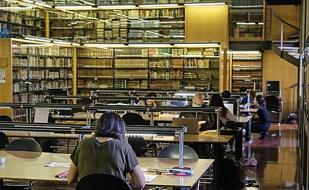Imagen principal - Parte de la sala de investigadores del Koldo Mitxelena se ha habilitado como zona de estudio. La biblioteca de Arraste. Una estudiante en una biblioteca.