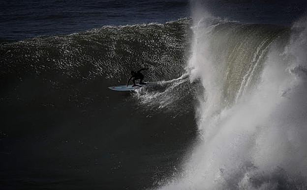 Galería. Un joven hace surf en la cala de Orrua, en Zumaia