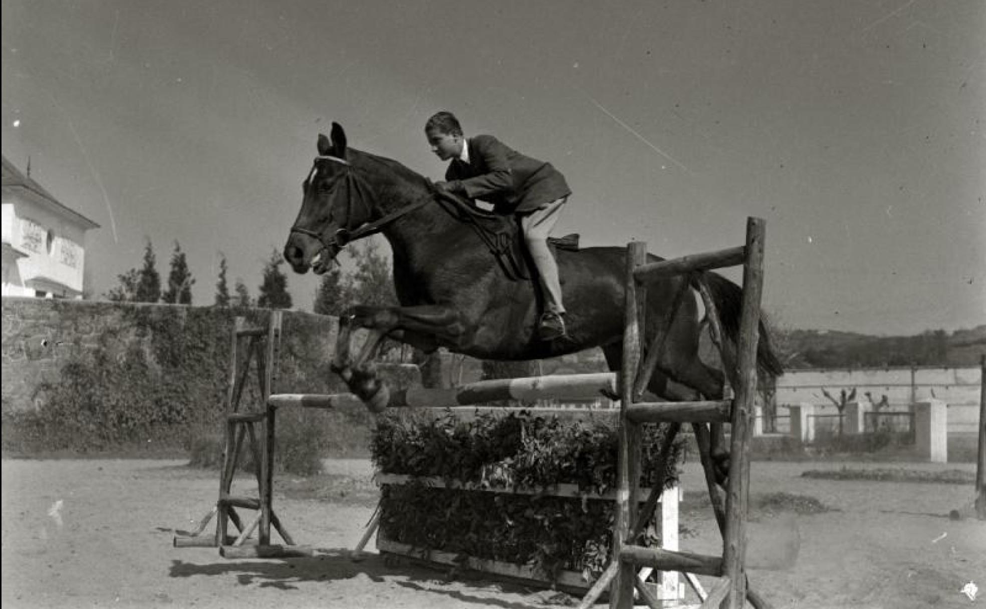 Fotografía histórica en la que se puede ver a un joven Juan Carlos de Borbón saltando un obstáculo a lomos de un caballo en Loiola. 