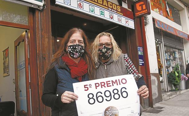 Ainhoa Albisu y Yolanda Pérez muestran felices el número premiado en su estanco de Irun.