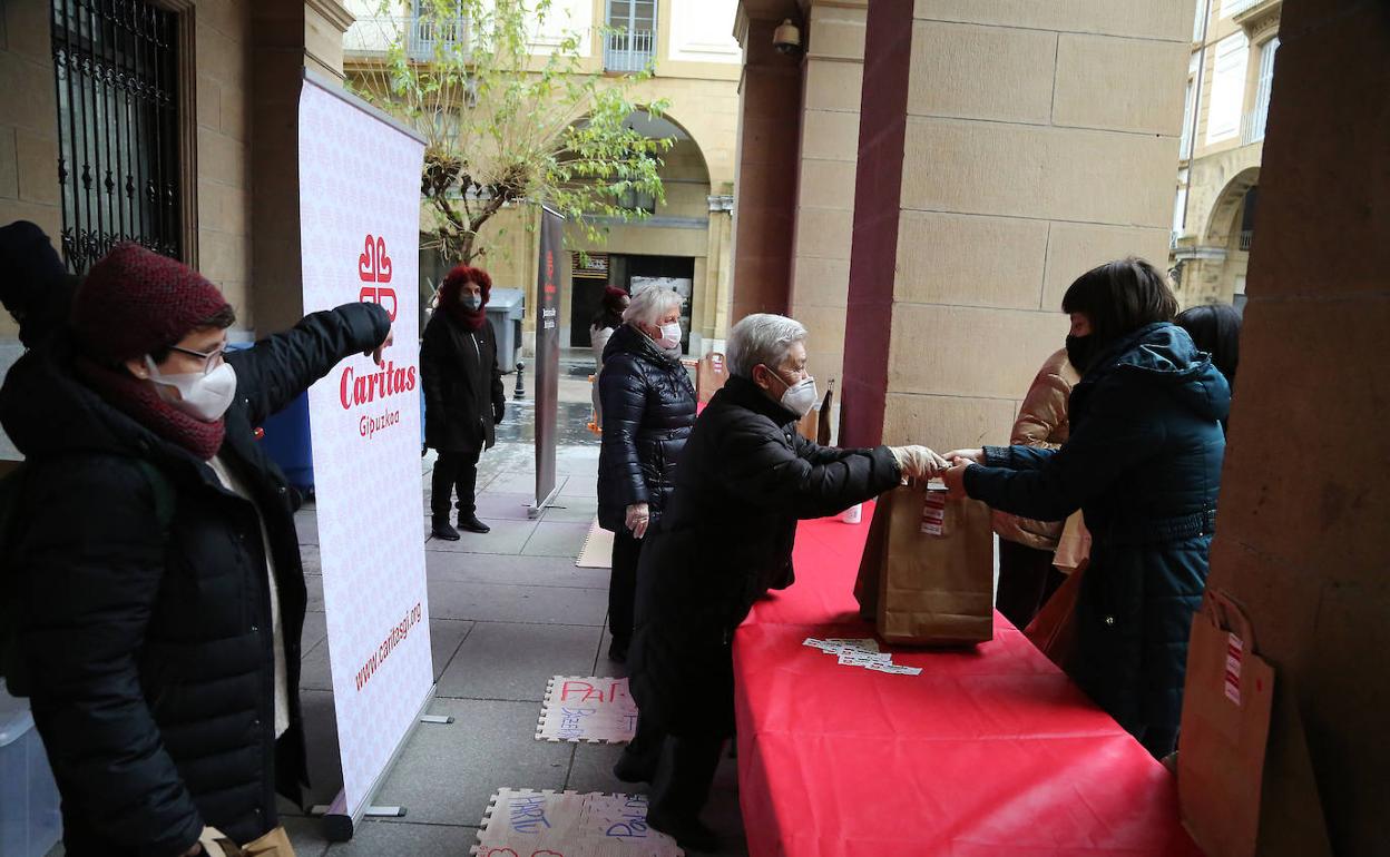 Voluntarias de Cáritas Gipuzkoa entregan las bolsas con las porciones de roscón. 