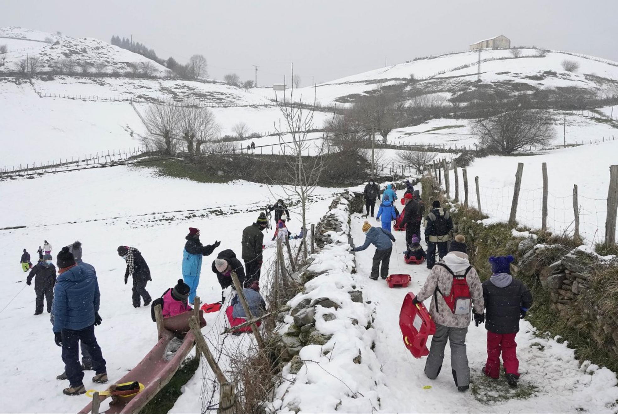 Decenas de personas con sus trineos en los terrenos cercanos a la ermita de SanSebastián de Berastegi. 