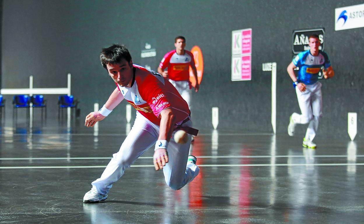 Elezkano II se lanza al suelo para devolver una pelota con Zabaleta y Mariezkurrena II al fondo, ayer en el Izarraitz de Azpeitia. 