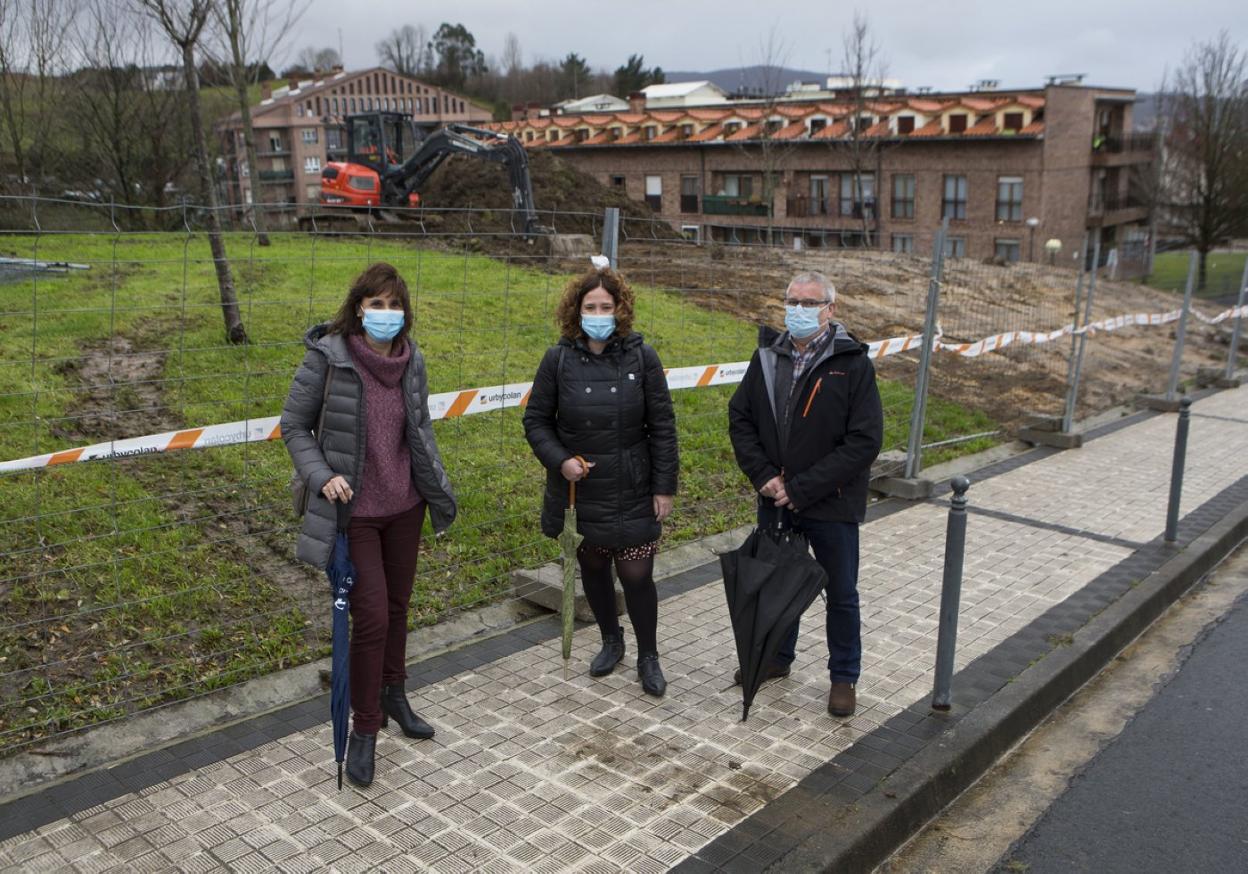 Ana Baena, directora del área de Obras, la delegada Cristina Laborda y el presidente de la AVV de Artía, José Barreiro, ayer en la zona donde se ampliará el aparcamiento. 