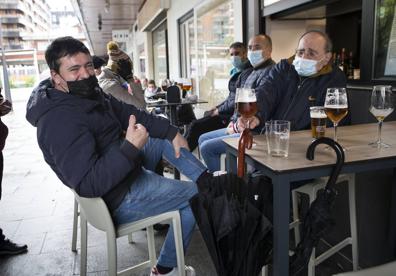 Imagen secundaria 1 - Lorena, Sonia y Jimena disfrutaban ayer juntas tomando algo después de haber terminado su paseo. La próxima, dicen, será en casa; Aitor y sus amigos lamentan que solo tenga que cerrar la hostelería y Antonio, del bar Gaztelumendi, no sabe cuánto podrán aguantar esta situación.