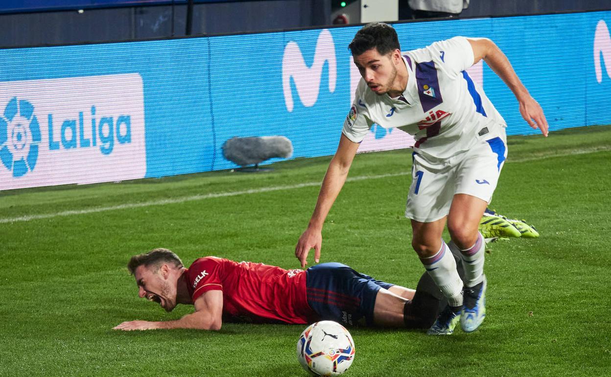 Soares trata de avanzar con Barja tendido en el césped ayer en El Sadar. 