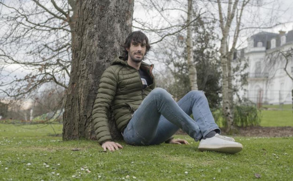 Carlos Martínez, sentado y apoyado en un árbol en el Palacio de Aiete de Donostia.