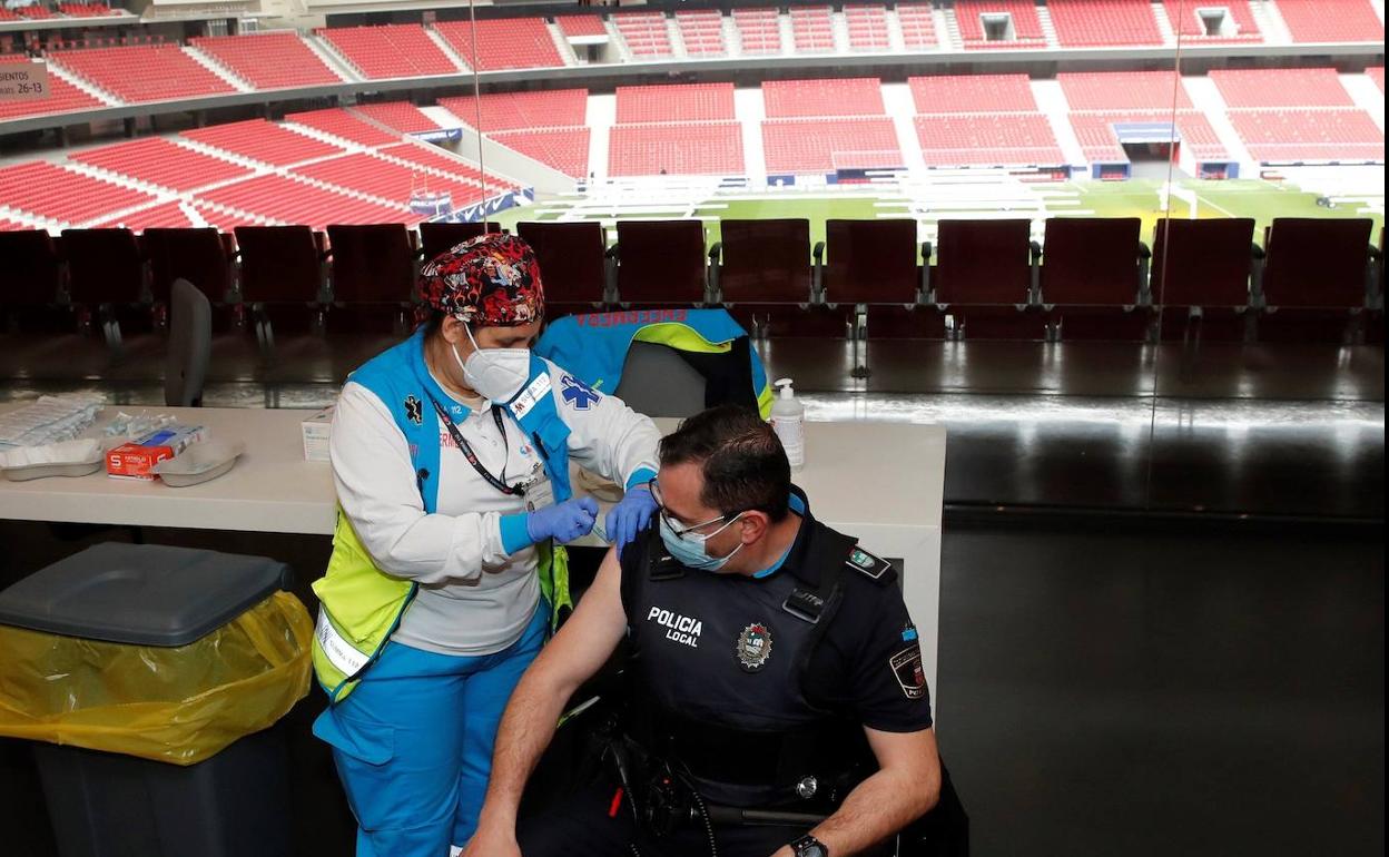 Un policía es vacunado en el Wanda Metropolitano, estadio del Atlético de Madrid.