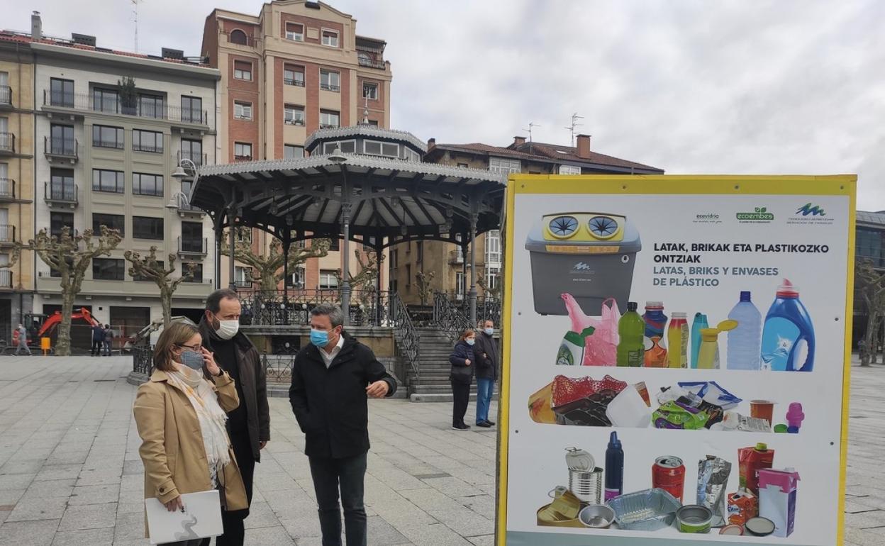 La gerente de Servicios de Txingudi, Leire Zubitur, y los alcaldes de Irun y Hondarribia, José Antonio Santano y Txomin Sagarzazu, respectivamente, junto a uno de los cubos informativos de la plaza Ensanche. 