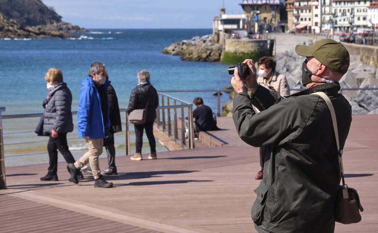 Paseantes disfrutan del buen tiempo en las inmediaciones de La Concha en Donostia. usoz