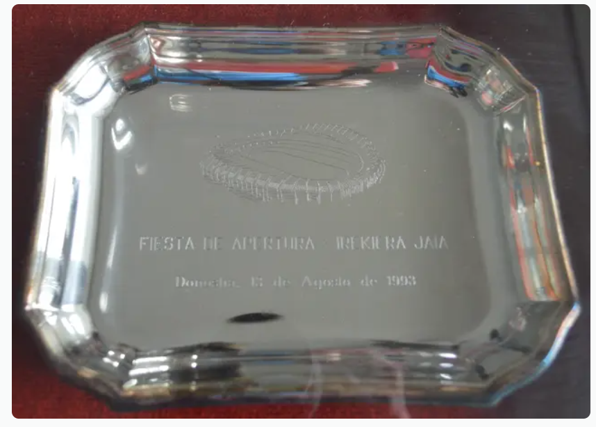 Placa de plata conmemorativa de la inauguración del estadio de Anoeta el 13 de agosto en un amistoso disputado el 13 de agosto de 1993 entre la Real Sociedad y el Real Madrid. A la fiesta de inauguración se le conoció con el nombre de "Kaixo Anoeta". Su vendedor pide 200 euros por esta placa conmemorativa.