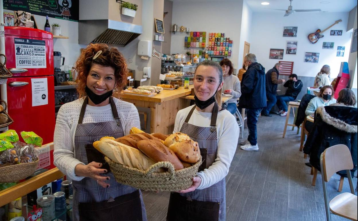 Olatz (izda.) y una compañera muestran una cesta de variados panes en el Tribeka. 