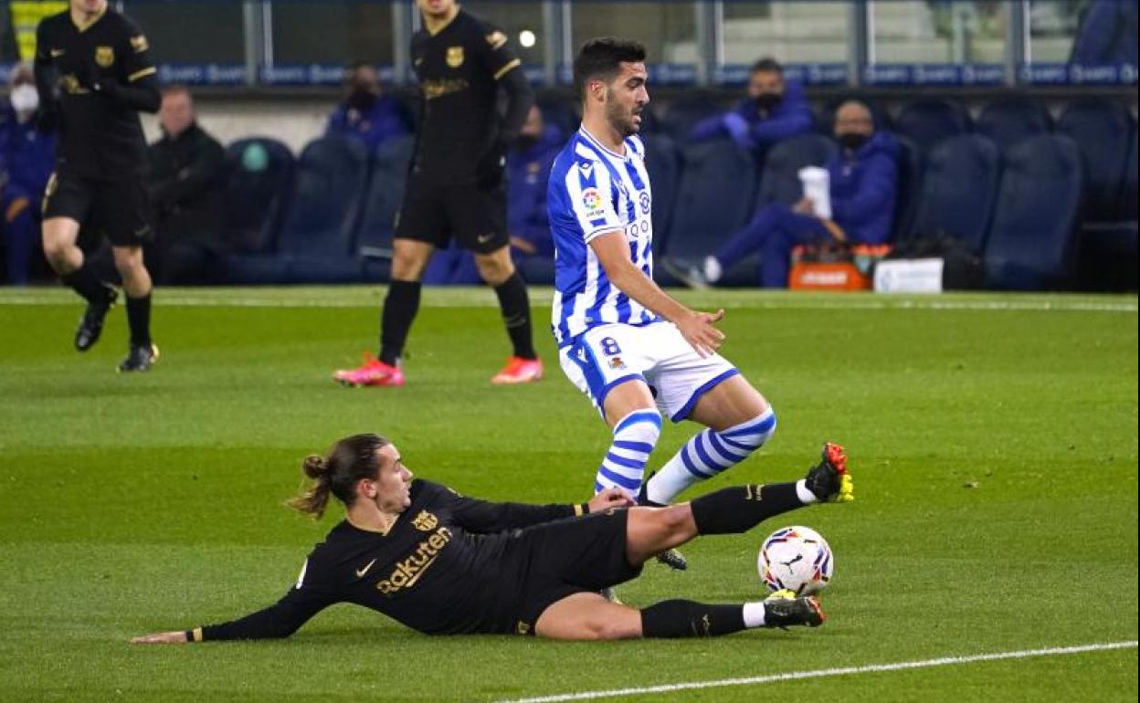 Mikel Merino evita la entrada de Antoine Griezmann,.