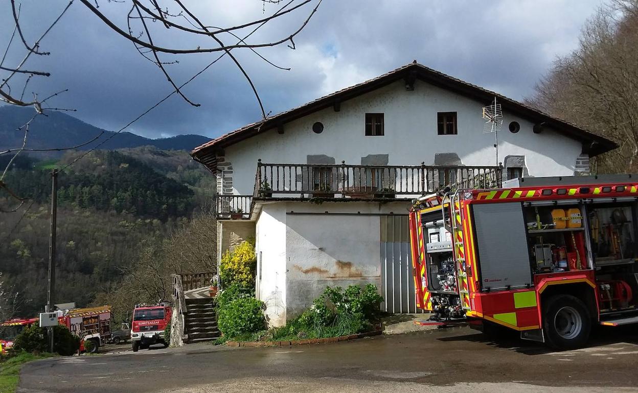 Los camiones de bomberos junto al caserío que ha sufrido el incendio