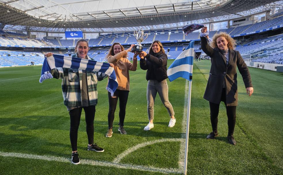 Ane Etxezarreta y Kiana Palacios sujetan la Copa conquistada enmayo de 2019, con Nuria Mendozaa su derecha y Mariasun Quiñonesa su izquierda, animando todas ala Real en vísperas de disputar otra final
