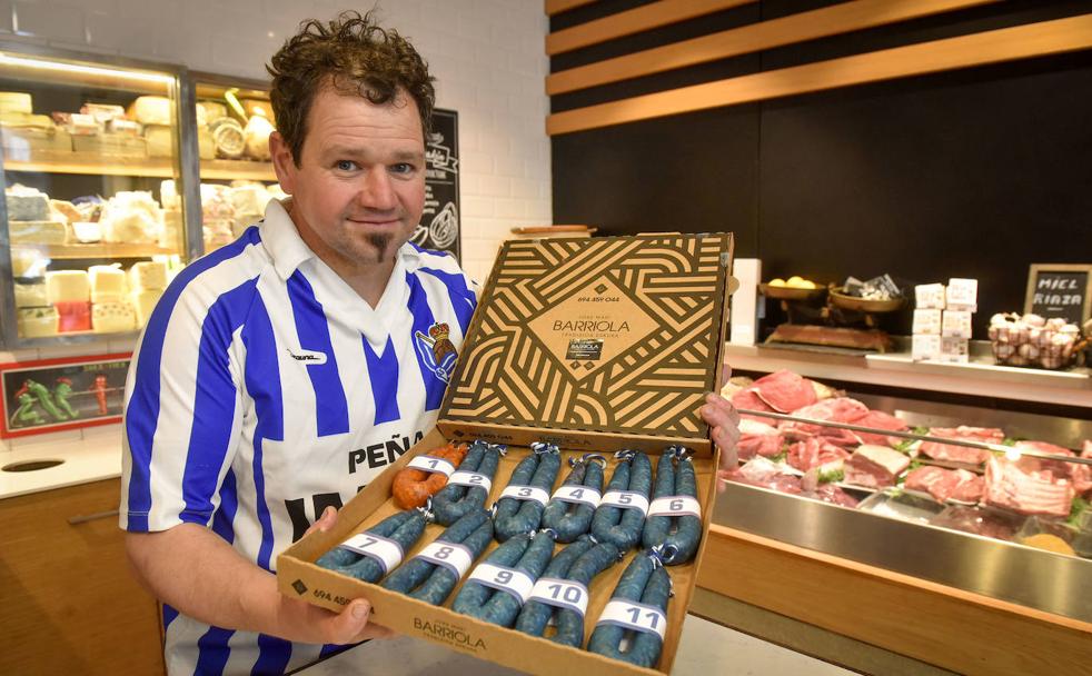 Joxe Mari Barriola posa con una caja de txistorras inspirada en los colores de la Real Sociedad. 